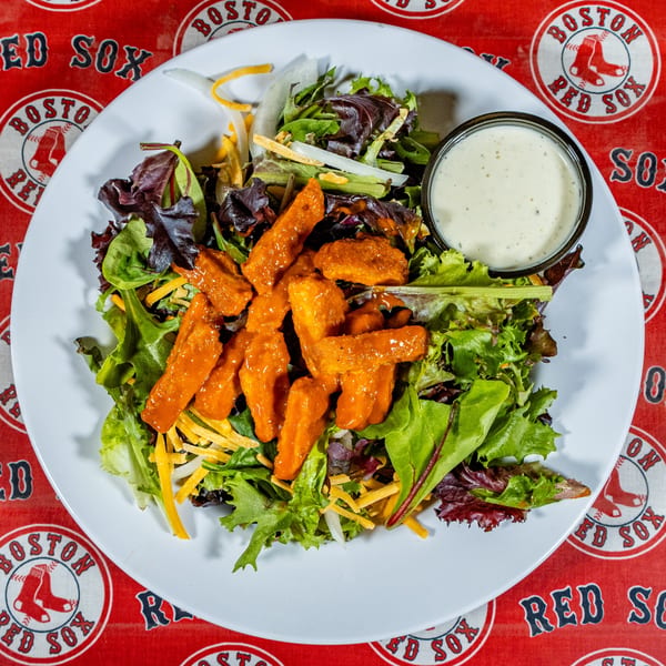 A Matty G's buffalo chicken salad with mixed greens, cheese, and ranch dressing on a Red Sox tablecloth.