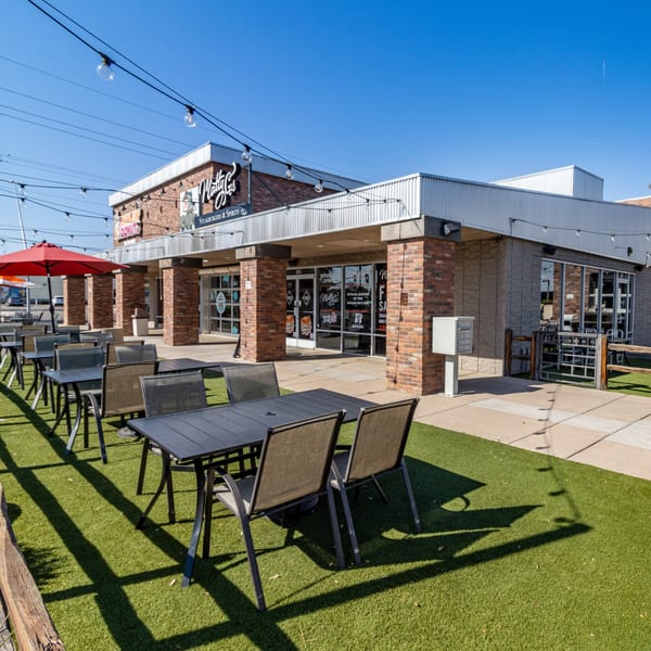 Matty G's Steakburgers exterior with outdoor patio seating on artificial turf under string lights.